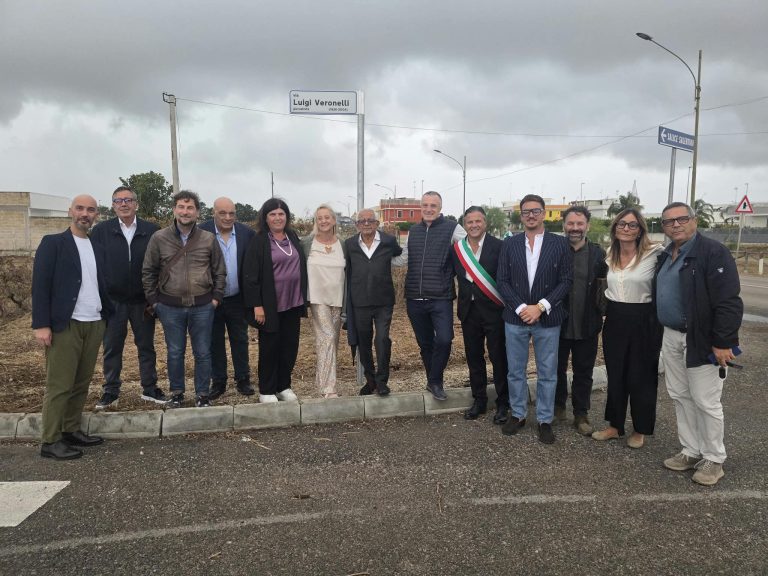 Protagonisti dell'evento davanti al palo segnaletico dedicato a Luigi Veronelli